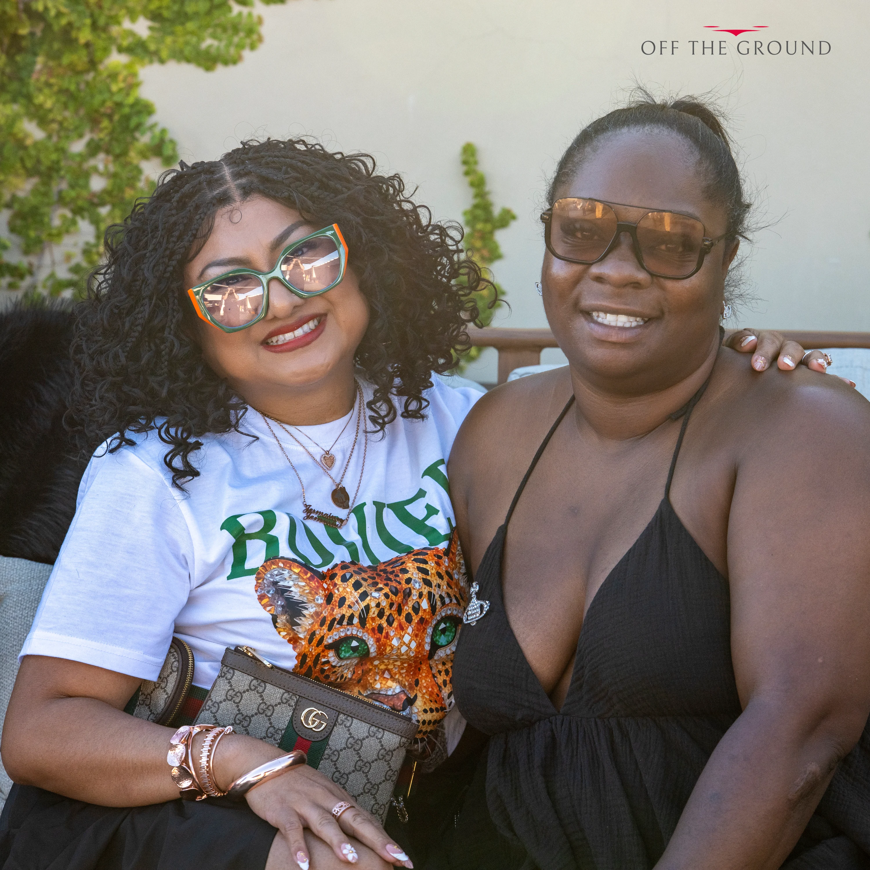 Two women posing together and smiling at the rooftop party