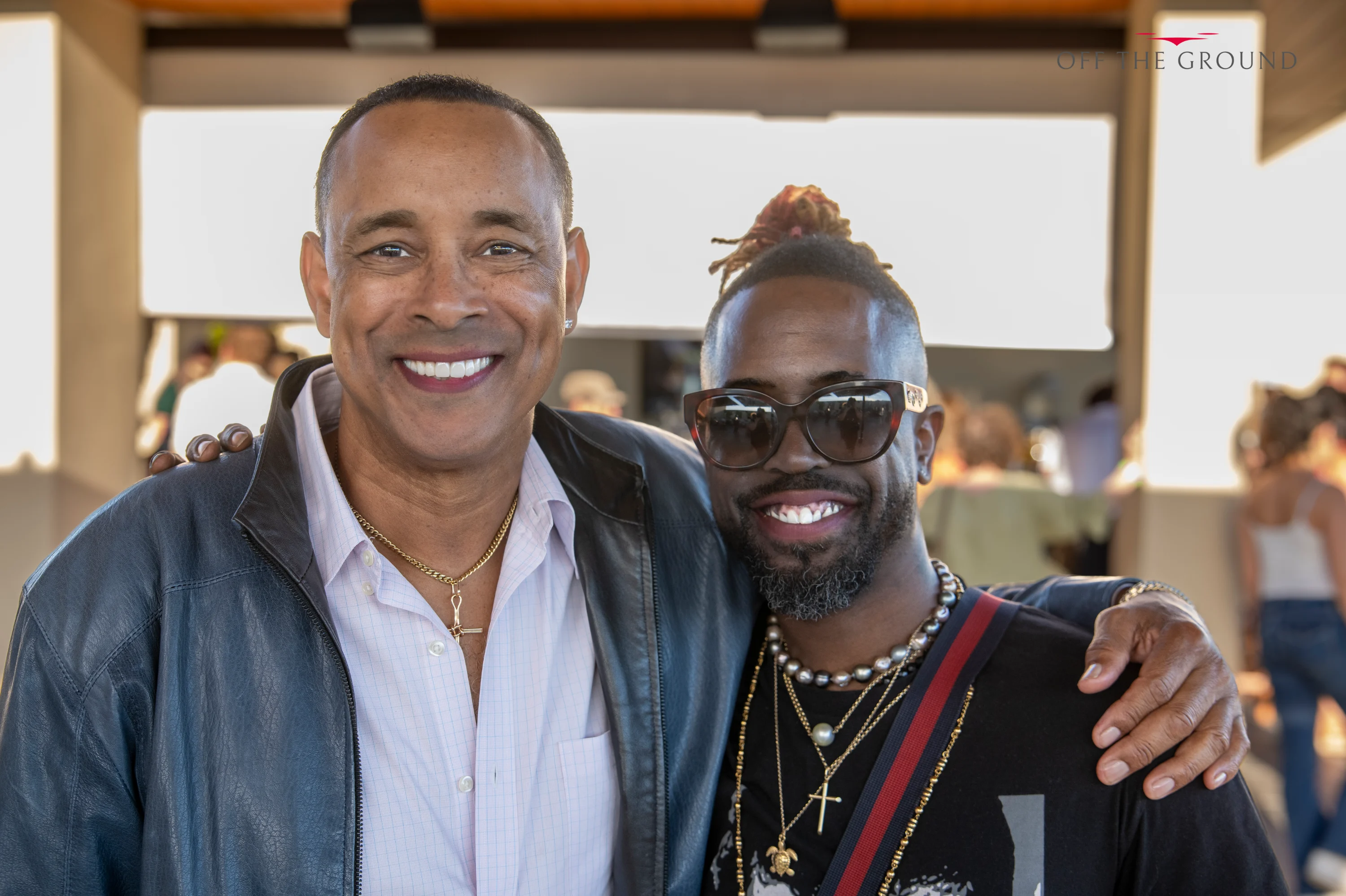 Two men posing arm in arm and smiling at the party